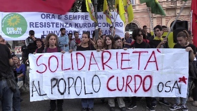 Scene from Curdi, manifestanti mettono in scena la lotta contro Isis: falò dei simboli del Daesh