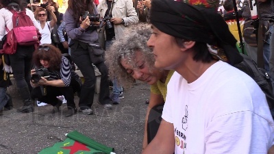 Scene from Curdi, manifestanti mettono in scena la lotta contro Isis: falò dei simboli del Daesh