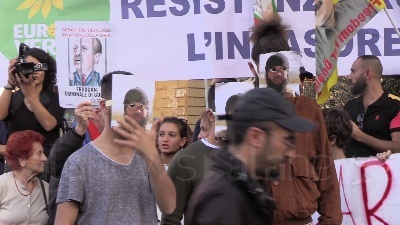Scene from Curdi, manifestanti mettono in scena la lotta contro Isis: falò dei simboli del Daesh