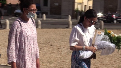 Scene from Ambasciata britannica, bandiere a mezz'asta e fiori per la regina dai passanti