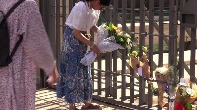 Scene from Ambasciata britannica, bandiere a mezz'asta e fiori per la regina dai passanti