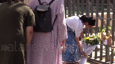 Scene from Ambasciata britannica, bandiere a mezz'asta e fiori per la regina dai passanti